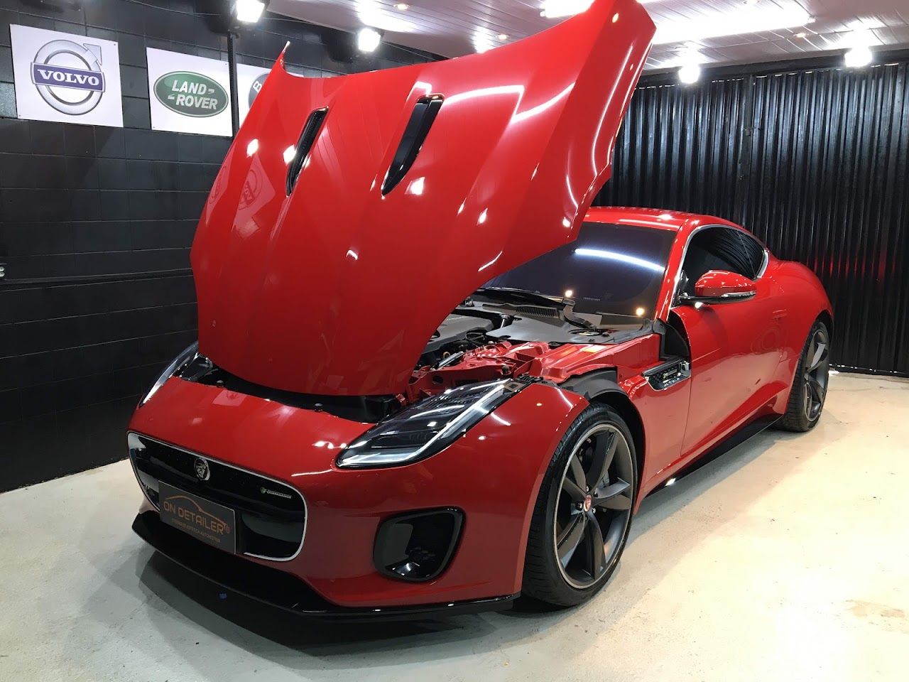 Jaguar vermelho de capô aberto no estúdio